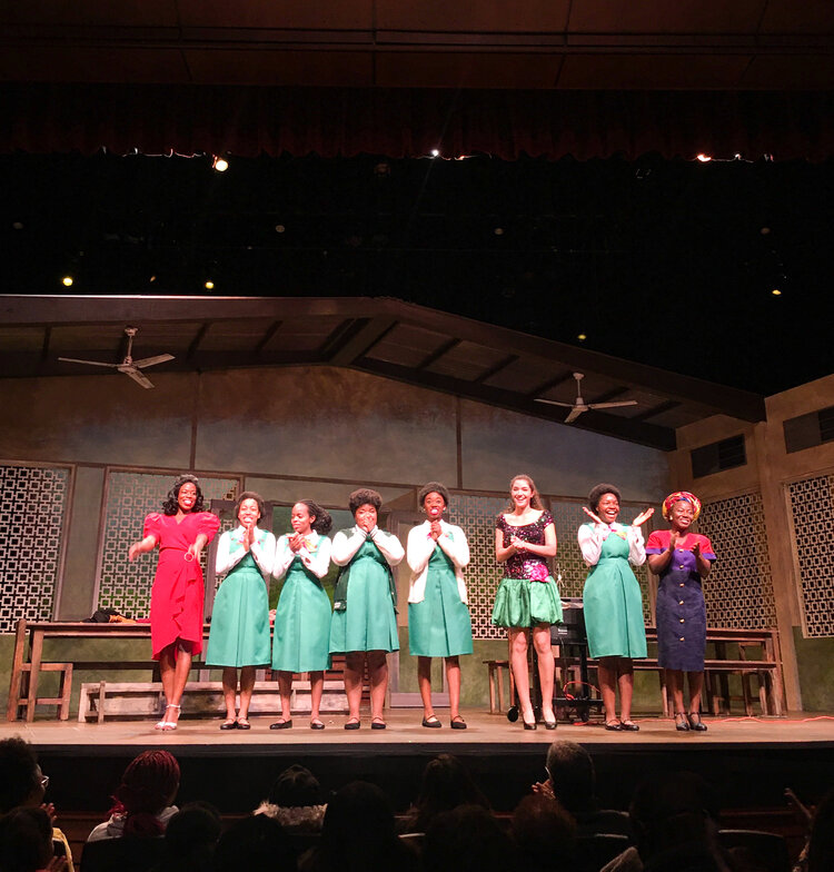 Cast of School Girls standing on the stage and applauding at the True Colors Theater in Black Atlanta