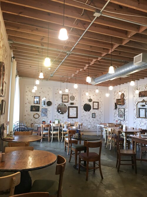 Empty main dining room of Le Petite Marche several hanging ceiling lights in Black Atlanta