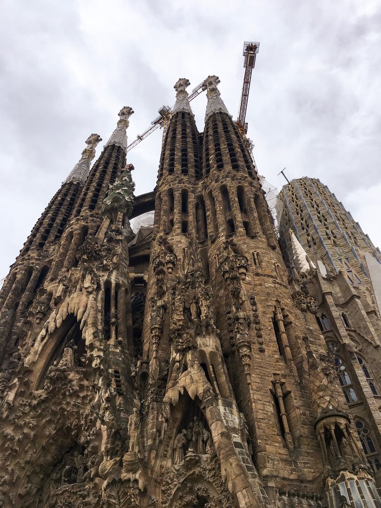 Looking up at the top towers of Sagrada Familia on an overcast day