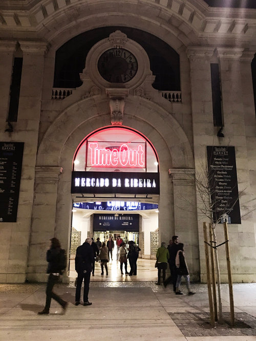 People outside of the front entrance of Time Out Market in Lisbon Portugal at night