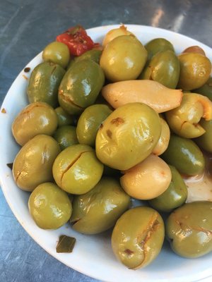 Small plate piled high with Spanish olives and garlic, drizzled with olive oil