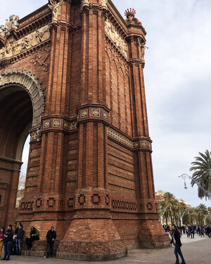 Side of Arc de Triomf with tourists gathered in front in Barcelona