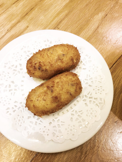 Small white plate of two chicken croquettes in Spain