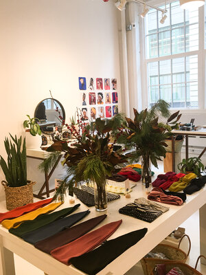 Table of colorful head wraps and green plants at The Wrap Life women owned business in Brooklyn New York