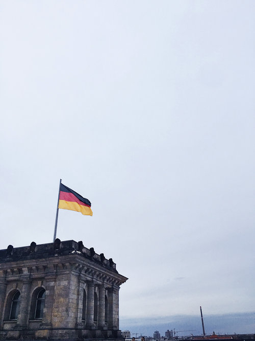 The west side of The Reichstag building with the German flag flying in Berlin Germany in Europe