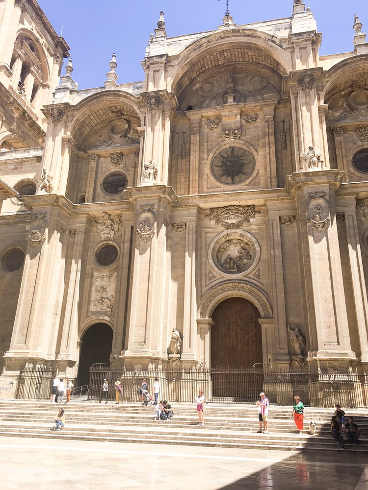 Tourists in front of the Granada Cathedral on a sunny day