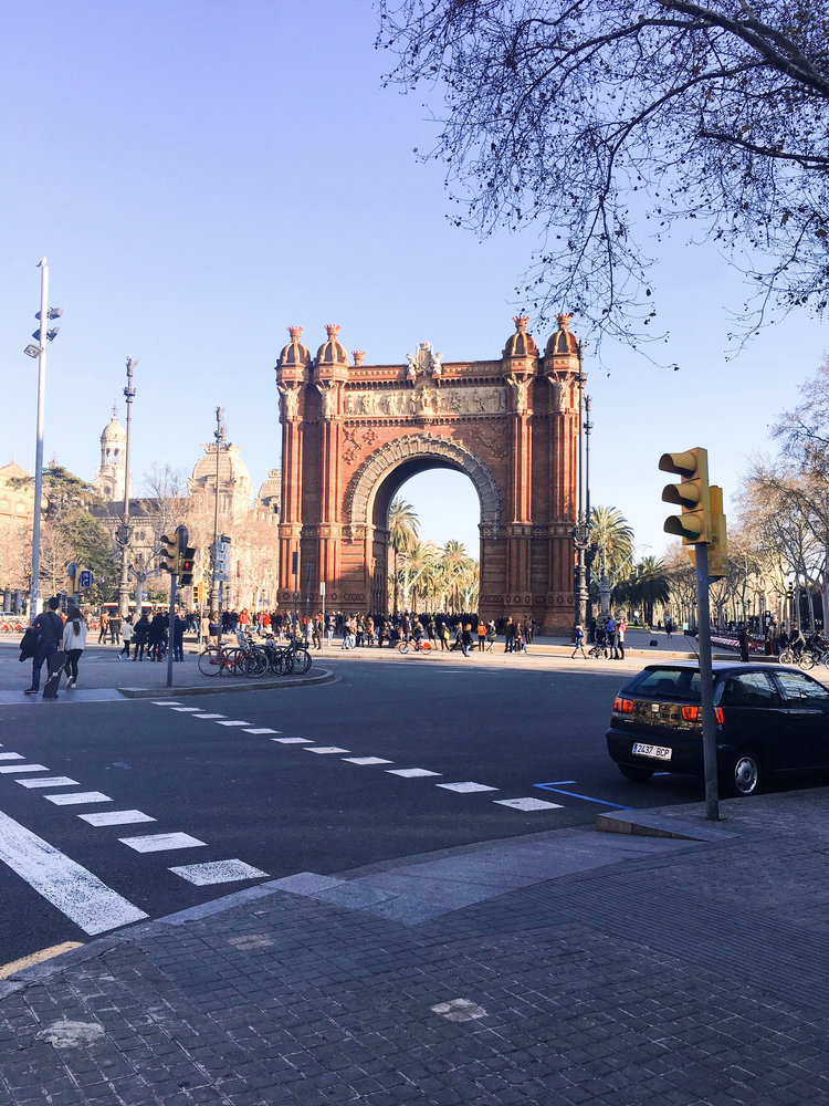 Tourists walking in front of the Arc de Triomf in Barcelona Spain on a sunny day
