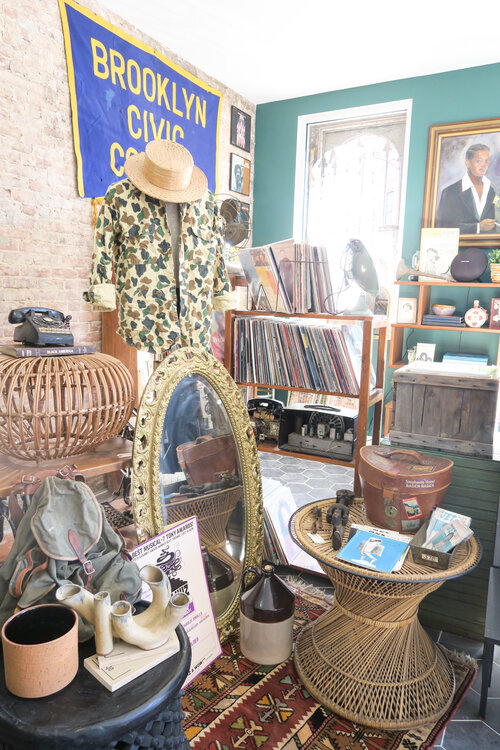 Vintage displays of clothing, pictures, and household items at BLK MKT Vintage in Brooklyn New York City