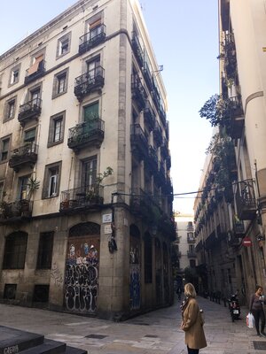 Woman standing on narrow street corner in Barcelona Gothic neighborhood