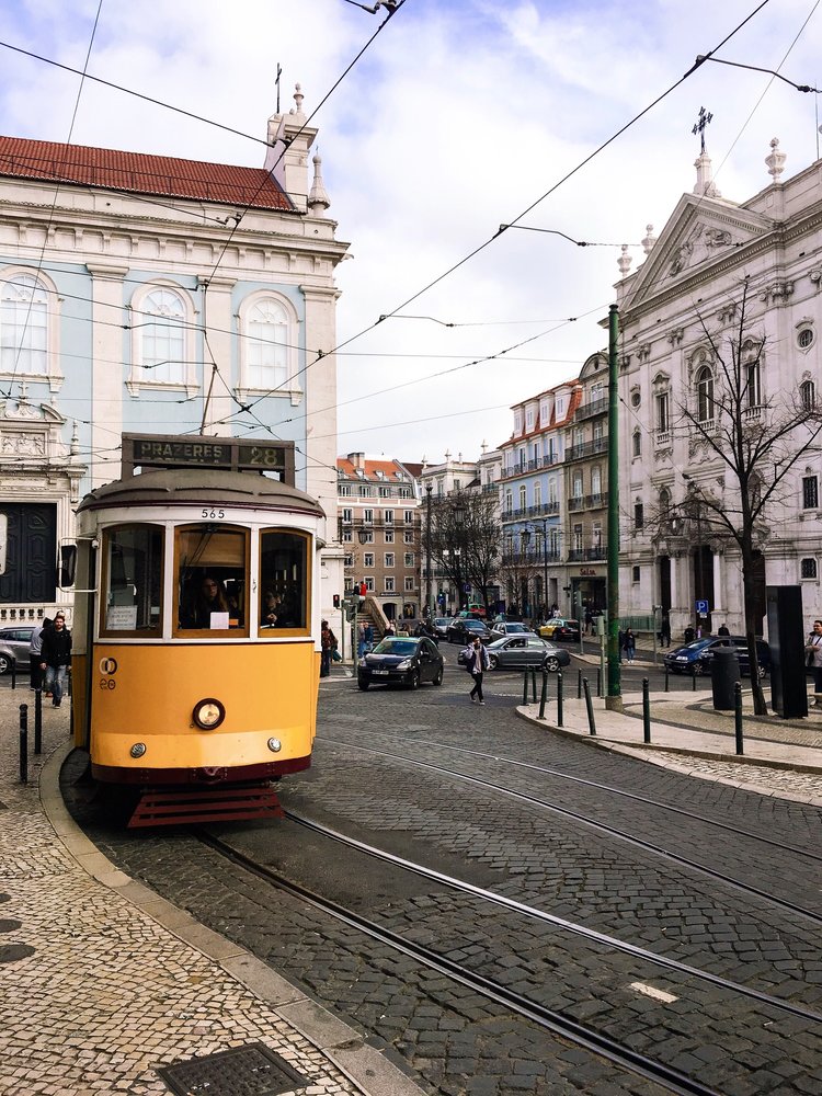 Yellow Tram 28 on the cobblestone streets of Lisbon