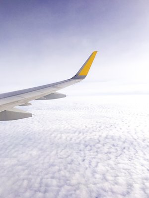 Airplane wing in the sky amongst the white clouds on a sunny day