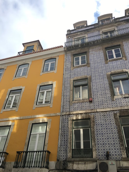 Yellow building attached to a blue tiled building in Lisbon Portugal on a sunny day