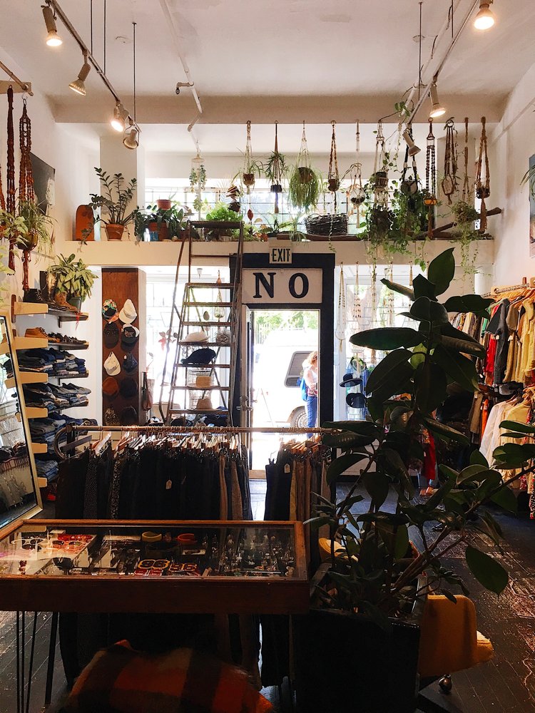 Inside No vintage store in San Francisco with colorful clothes and hanging plants. A great way to treat yourself.
