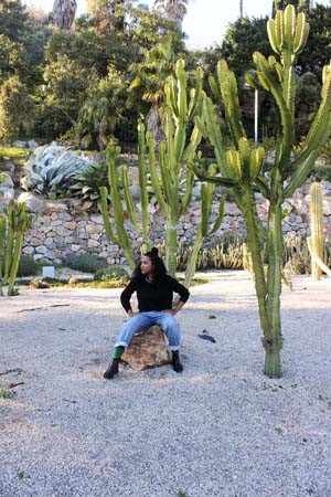 Kim-sitting-on-a-small-rock-traveling-alone-in-the-cactus-farm-in-barcelona-spain