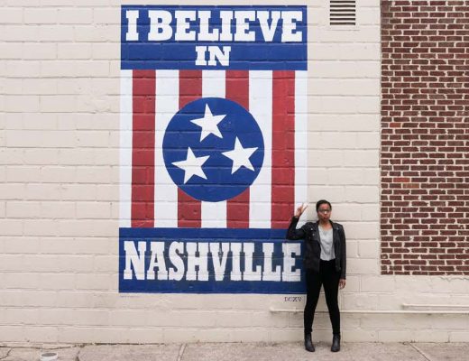 Kim standing in front of the I Believe Nashville Mural in Nashville Tennessee on a sunny day