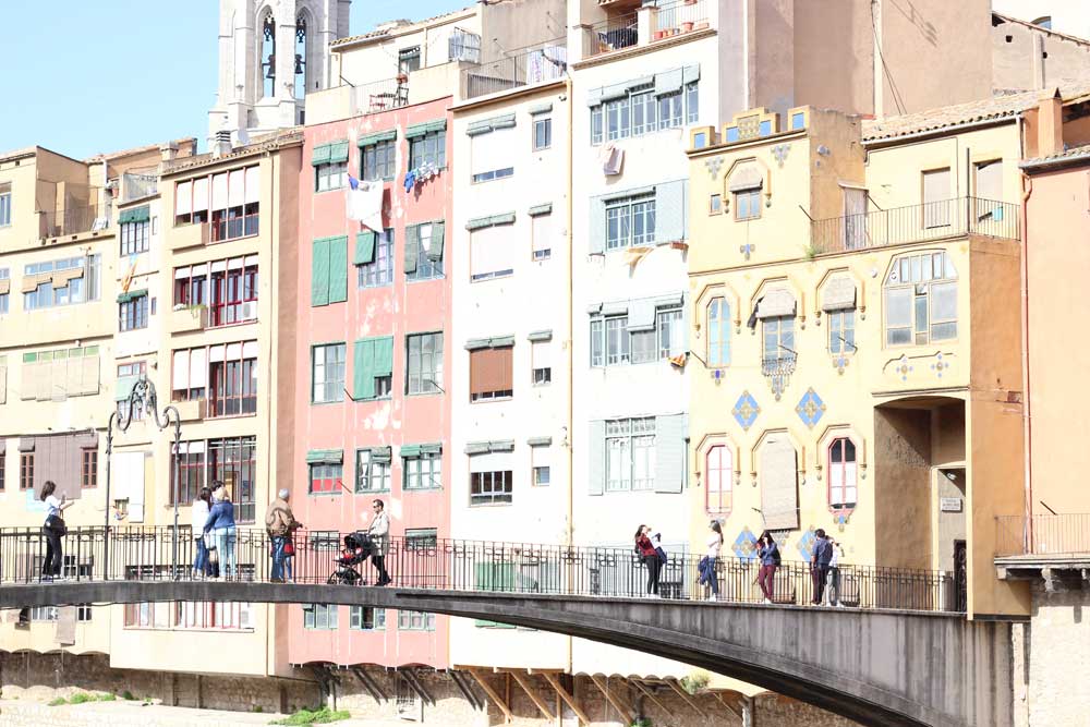 Famous colorful facade with bride and tourists in Girona Catalonia on a sunny day