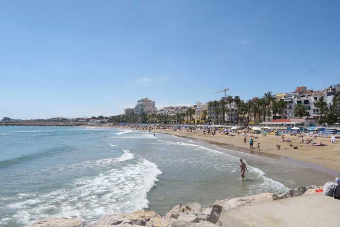The beach in Sitges filled with locals laying out in the sun and enjoying their Barcelona day trip.