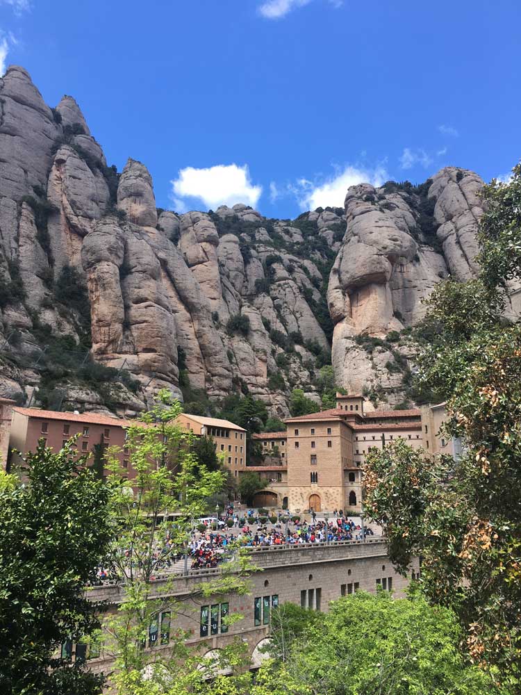 Top of Montserrat Mountain with tourists at the bottom on a Barcelona day trip