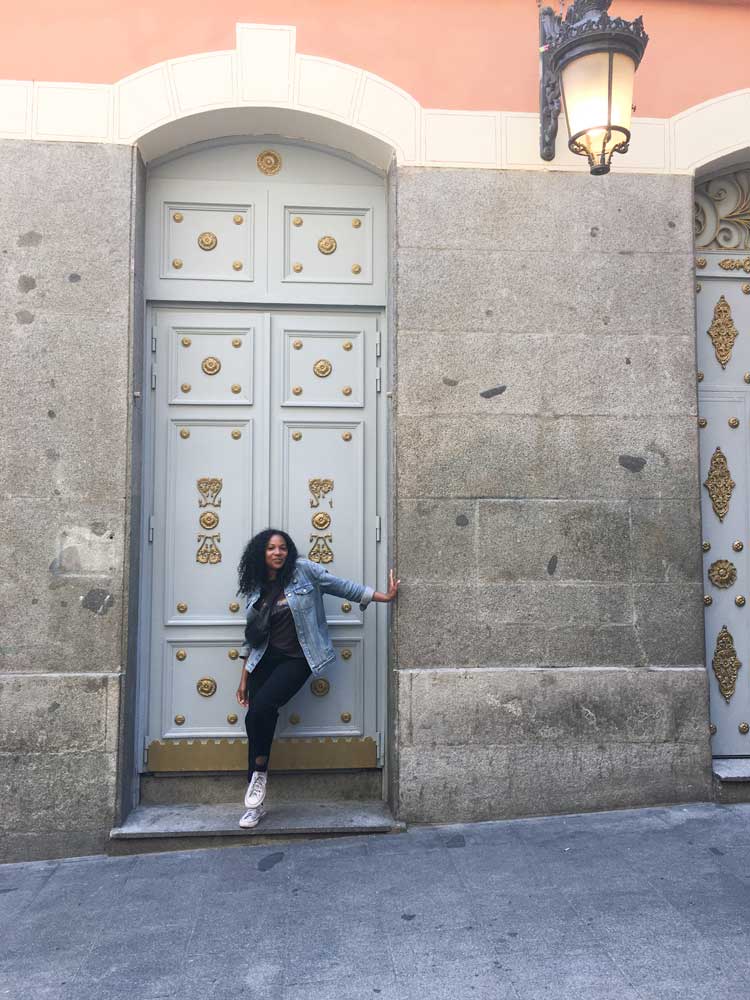 Kim standing in front of a decorative doorway in Madrid thinking about Madrid vs. Barcelona travel