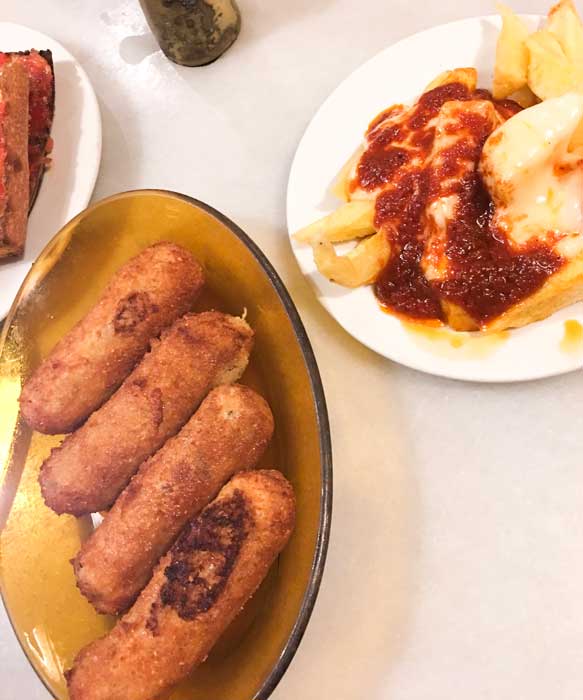 Plate of croquets and patatas bravas at Bar de Pla in Barcelona Spain